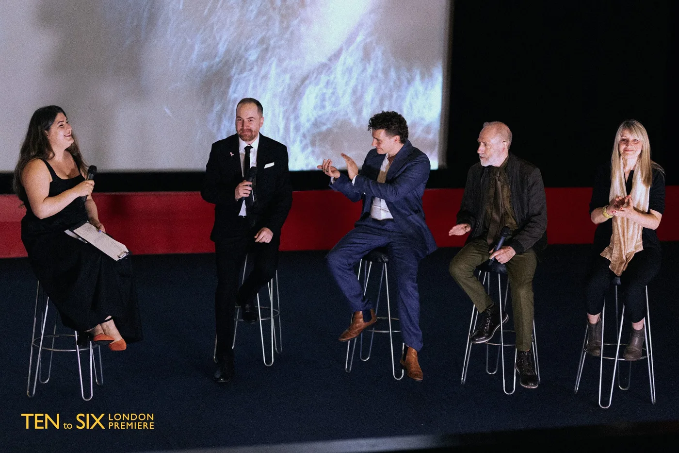 Five people seated on stools on a cinema stage for a question and answer session