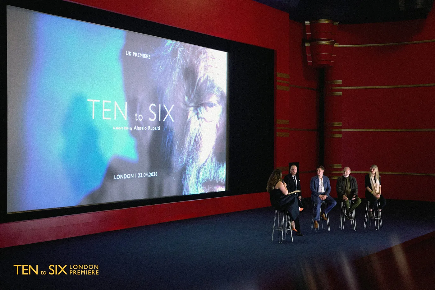 A cinema stage with the Ten to Six title on the screen and a panel seated below it